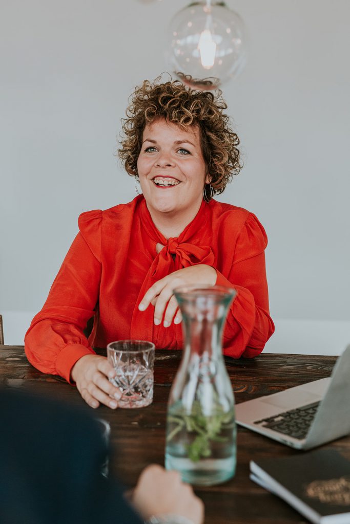 Lachend aan tafel om online jouw naamsbekendheid te vergroten